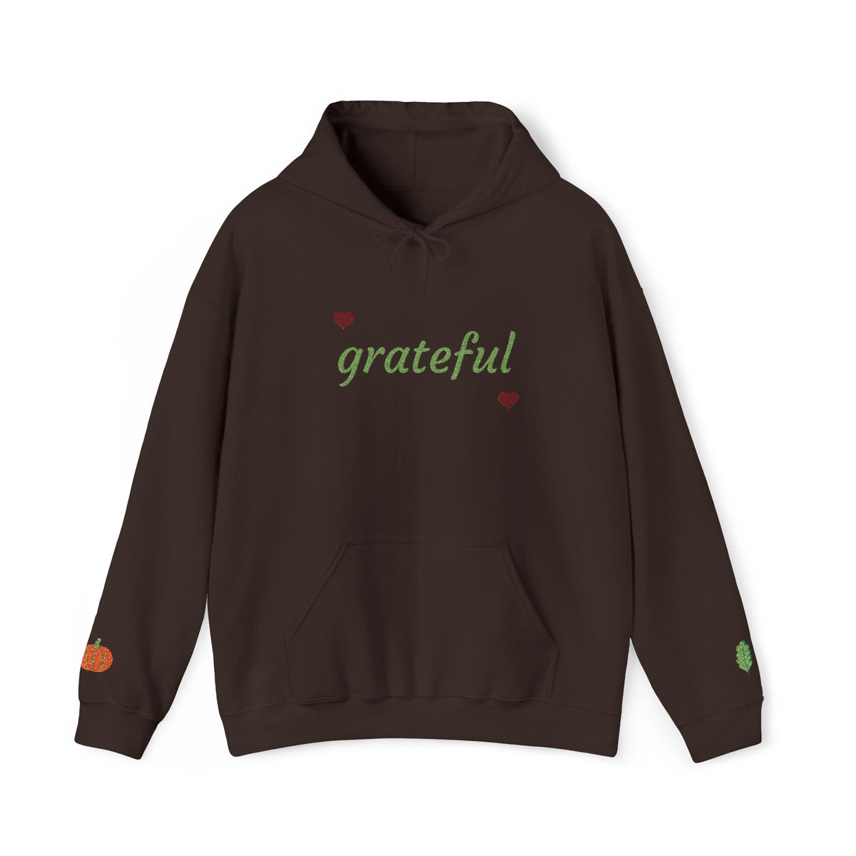 A dark brown pullover hoodie with 'grateful' written in green script across the chest, flanked by two small red hearts. The hoodie features a drawstring hood, a front kangaroo pocket, a small orange pumpkin graphic on the right sleeve, and a small green leaf graphic on the left sleeve, shown against a plain white background.