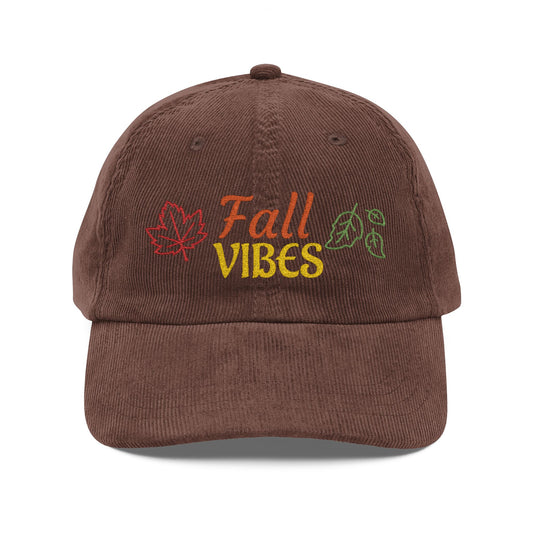 A brown corduroy baseball cap featuring embroidered 'Fall VIBES' text with autumn leaves on the front, set against a plain white background.